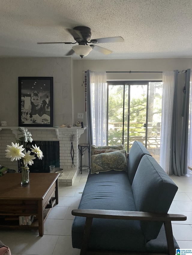 living room with ceiling fan, a fireplace, and a textured ceiling