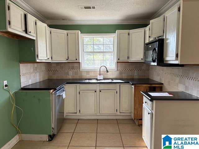 kitchen featuring tasteful backsplash, sink, light tile patterned floors, and a textured ceiling