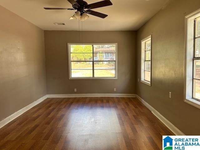 unfurnished room with plenty of natural light, dark hardwood / wood-style floors, and ceiling fan