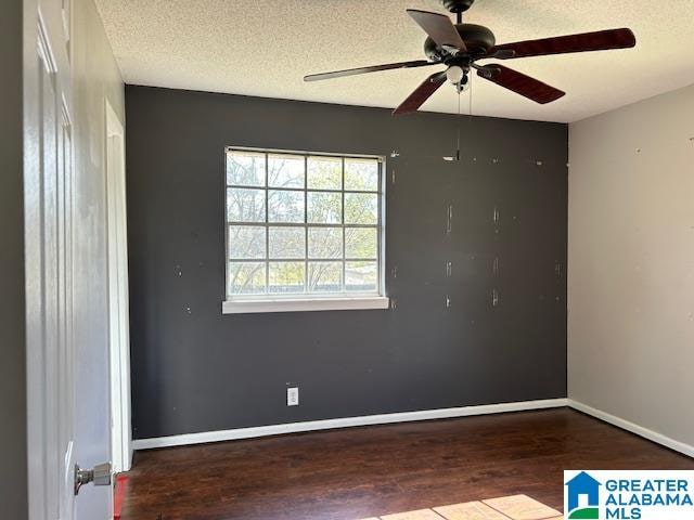 spare room featuring ceiling fan, a textured ceiling, and dark wood-type flooring