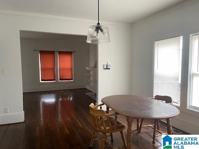 dining area featuring dark wood-type flooring and ornamental molding