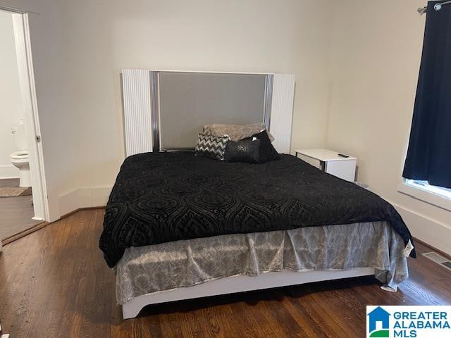 bedroom featuring dark hardwood / wood-style floors and connected bathroom