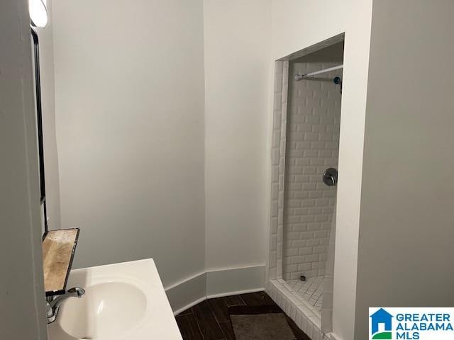 bathroom with a tile shower and sink