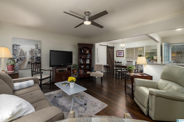 living room with dark hardwood / wood-style floors, a barn door, ornamental molding, and ceiling fan