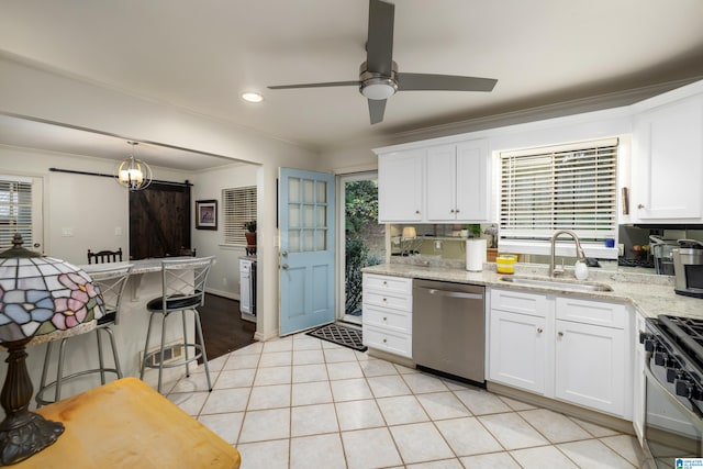 kitchen featuring a barn door, stainless steel appliances, white cabinetry, and sink