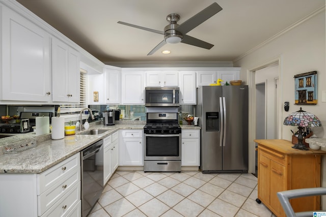 kitchen with sink, light stone countertops, ornamental molding, appliances with stainless steel finishes, and white cabinetry