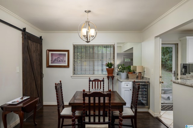 dining space with an inviting chandelier, wine cooler, a barn door, ornamental molding, and dark hardwood / wood-style flooring