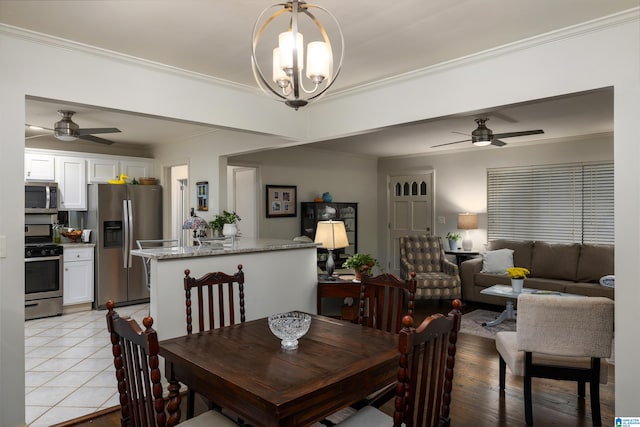 dining area featuring ceiling fan with notable chandelier, light wood-type flooring, and crown molding