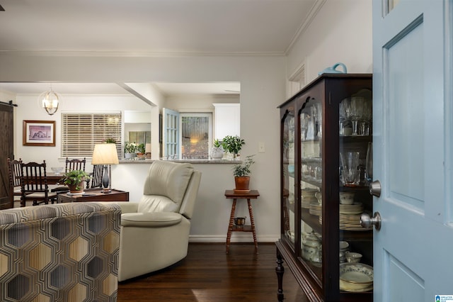 sitting room featuring dark hardwood / wood-style flooring, a barn door, and crown molding