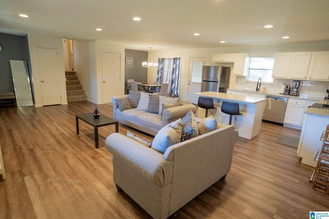 living room with light wood-type flooring and sink