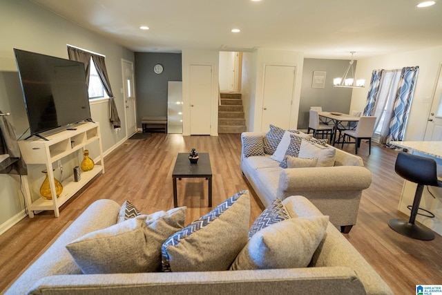 living room featuring wood-type flooring and a notable chandelier