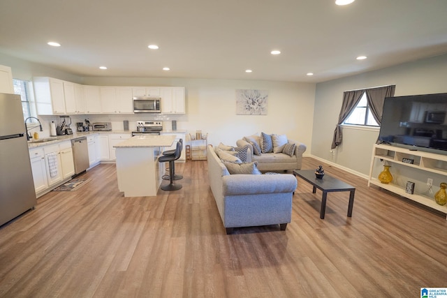 living room with light hardwood / wood-style flooring and sink