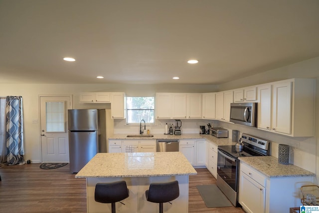 kitchen with a center island, sink, stainless steel appliances, and dark wood-type flooring