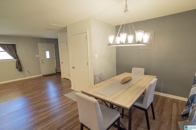 dining space with dark hardwood / wood-style flooring and an inviting chandelier