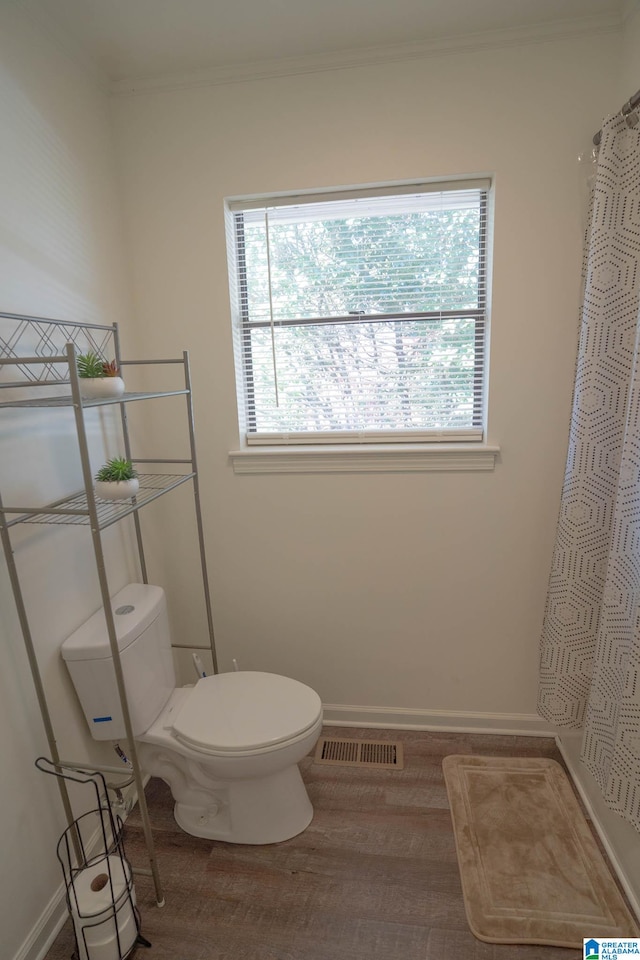 bathroom featuring hardwood / wood-style floors, toilet, and ornamental molding