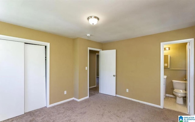 unfurnished bedroom featuring connected bathroom, light colored carpet, and a closet