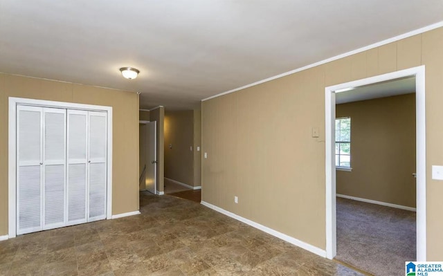 unfurnished bedroom featuring carpet flooring, a closet, and crown molding