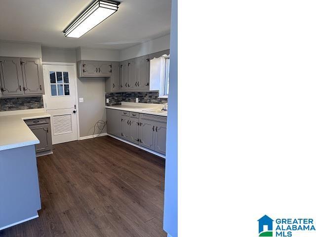 kitchen with dark hardwood / wood-style floors, gray cabinets, sink, and tasteful backsplash