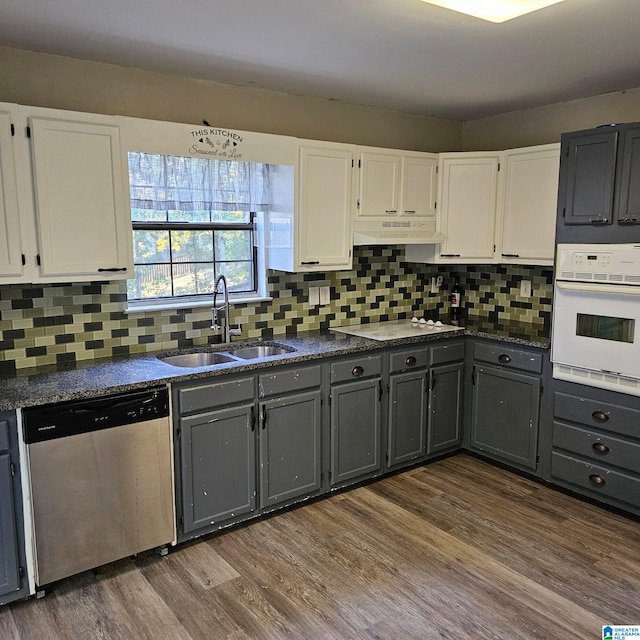 kitchen with dark hardwood / wood-style flooring, sink, white cabinets, and white appliances