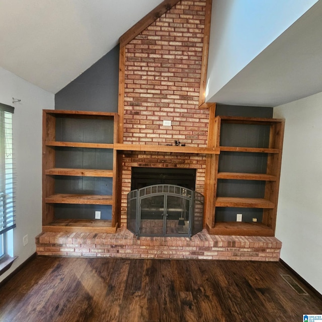 unfurnished living room featuring dark hardwood / wood-style flooring, vaulted ceiling, and a brick fireplace