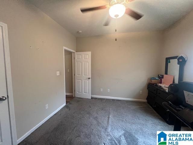 unfurnished bedroom featuring dark colored carpet and ceiling fan