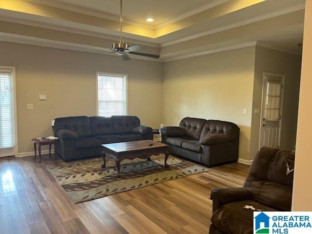 living room with crown molding, plenty of natural light, and hardwood / wood-style flooring