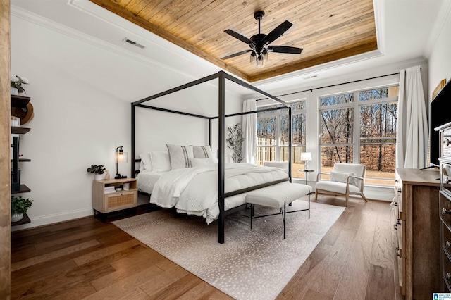 bedroom featuring wooden ceiling, hardwood / wood-style flooring, ceiling fan, ornamental molding, and a tray ceiling