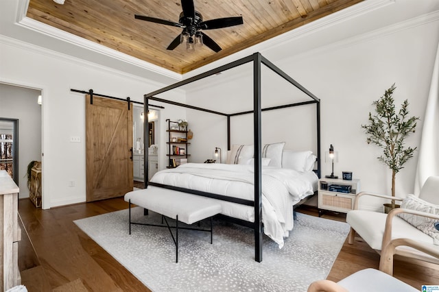 bedroom featuring dark hardwood / wood-style flooring, ceiling fan, crown molding, a barn door, and wooden ceiling