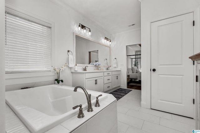 bathroom featuring tiled tub, crown molding, tile patterned flooring, and vanity