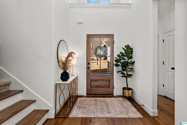 foyer entrance featuring hardwood / wood-style floors and crown molding