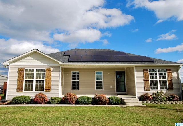 view of front facade with solar panels and a front lawn