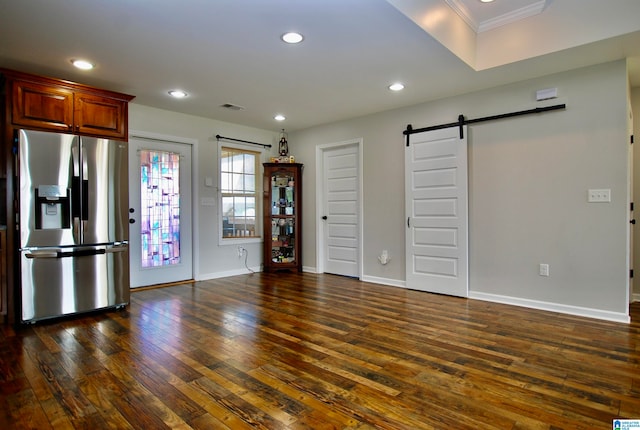 kitchen with stainless steel refrigerator with ice dispenser, a barn door, ornamental molding, and dark wood-type flooring