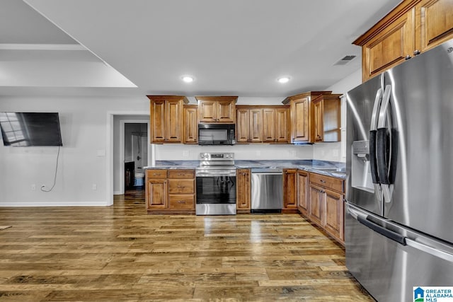 kitchen featuring appliances with stainless steel finishes and dark wood-type flooring