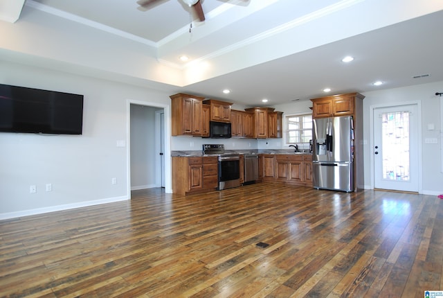 kitchen featuring plenty of natural light, ornamental molding, stainless steel appliances, and dark wood-type flooring