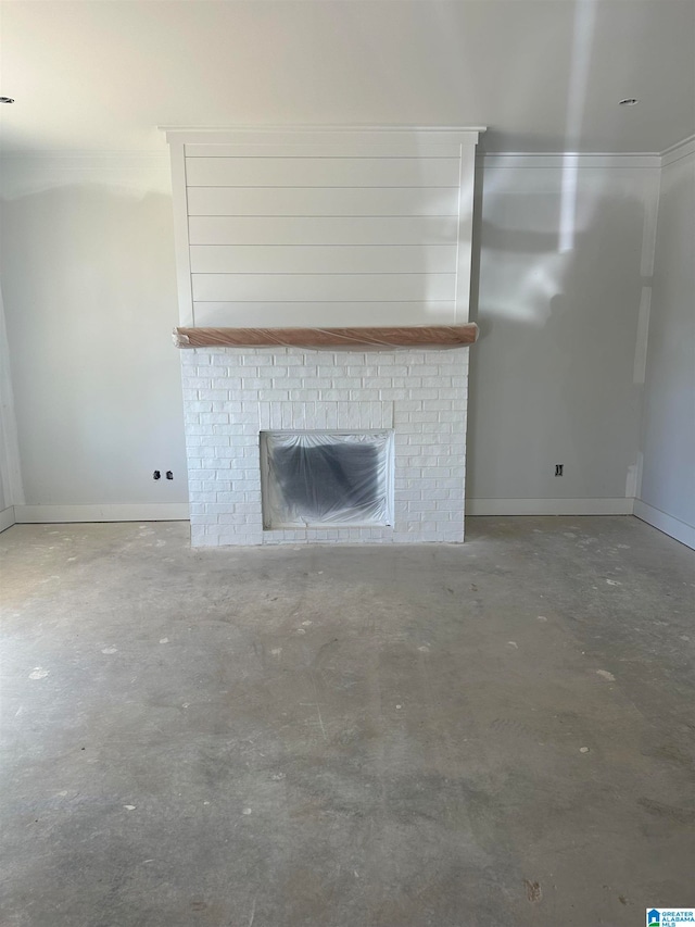 unfurnished living room featuring concrete flooring and a brick fireplace