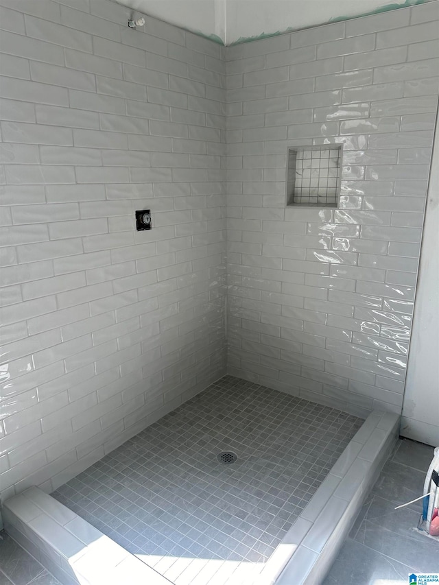 bathroom featuring tile patterned flooring and tiled shower