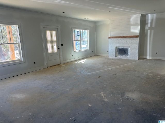 unfurnished living room featuring ornamental molding, a healthy amount of sunlight, and a brick fireplace