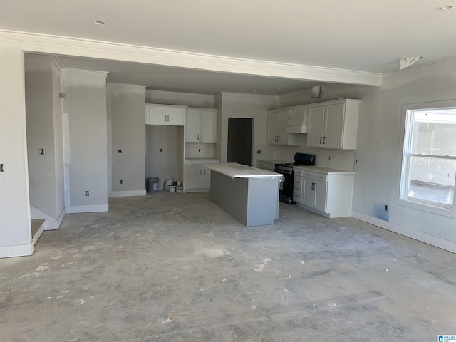 kitchen featuring black range oven, a kitchen island, white cabinets, and ornamental molding