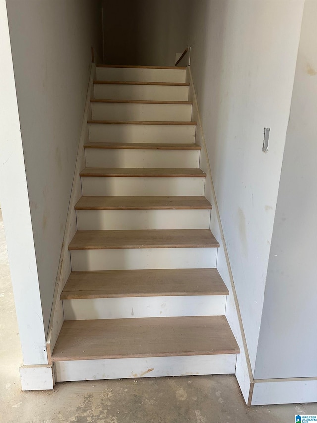 staircase featuring concrete floors