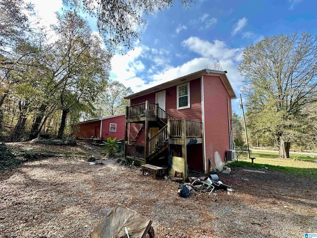 rear view of property featuring central AC and a wooden deck