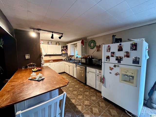 kitchen with rail lighting, sink, white refrigerator with ice dispenser, dishwasher, and white cabinetry