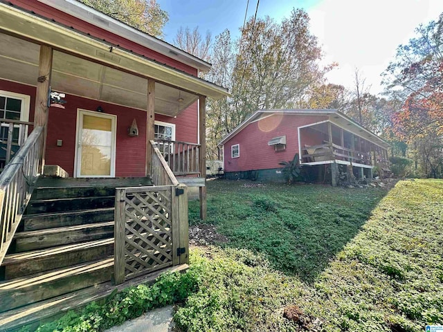 view of exterior entry with a porch and a lawn