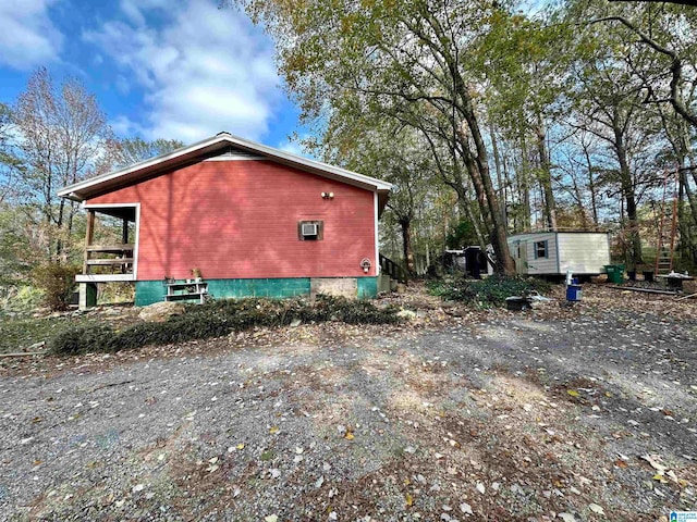 view of side of home featuring a storage shed