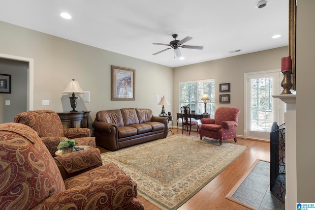 living room featuring ceiling fan and light hardwood / wood-style flooring