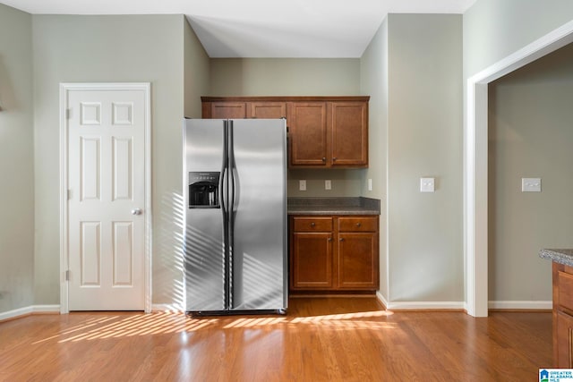 kitchen featuring stainless steel fridge with ice dispenser and light hardwood / wood-style flooring