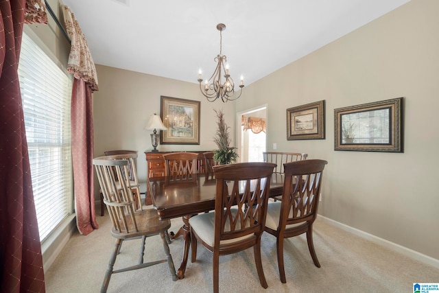 dining area with a chandelier, light colored carpet, and plenty of natural light