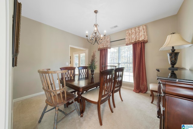 dining area with light carpet and an inviting chandelier