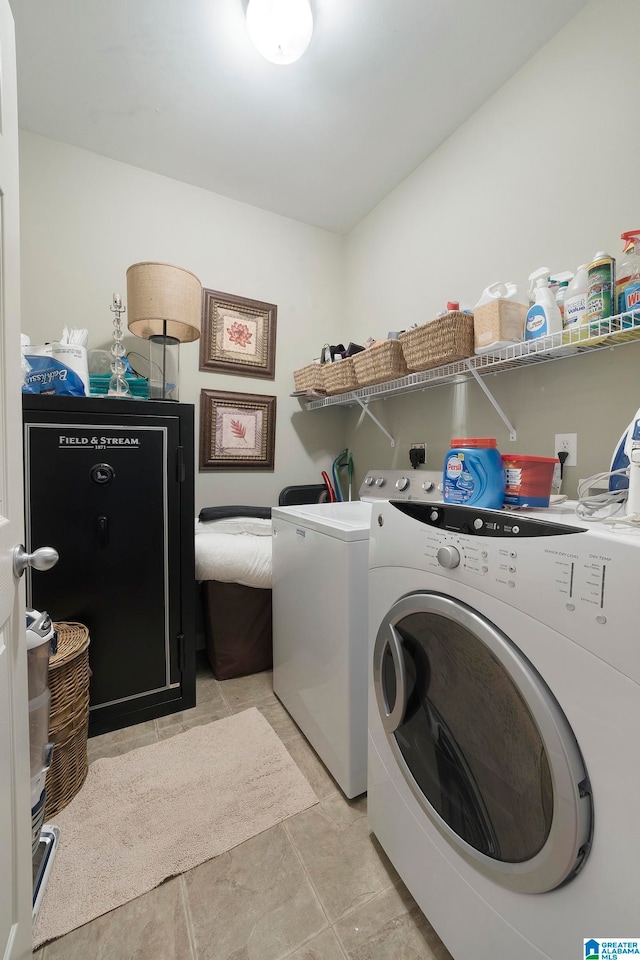 laundry area with washer and dryer and light tile patterned floors