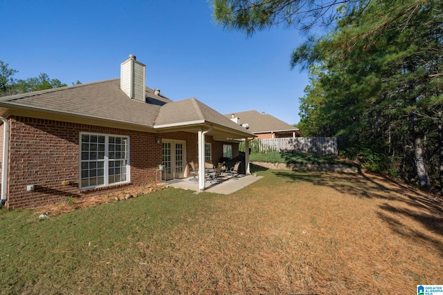 rear view of property with a lawn and a patio area