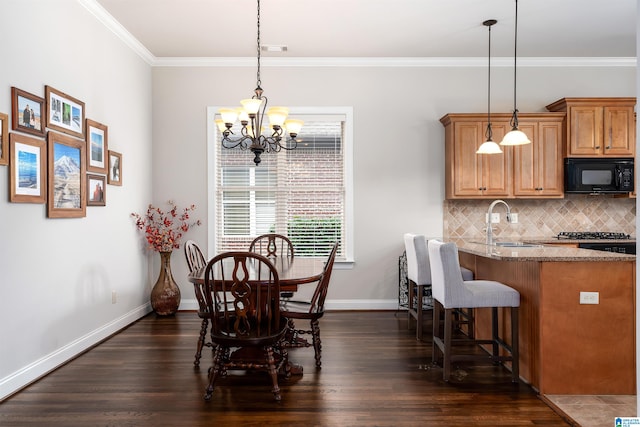 dining room featuring crown molding, sink, dark hardwood / wood-style floors, and an inviting chandelier